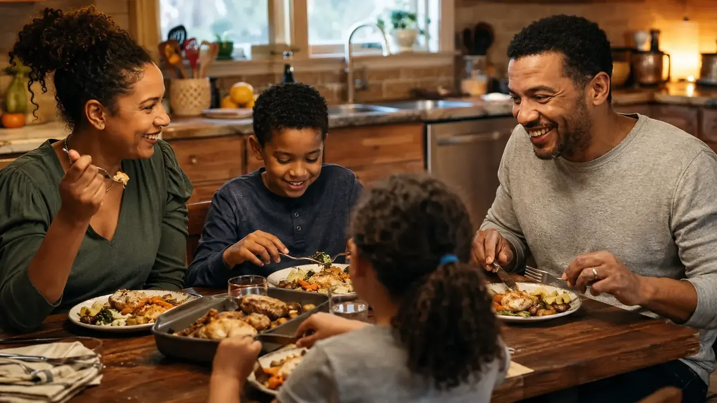A family dinner table set with plates of air-fried chicken, vegetables, and fries, everyone seated and eating